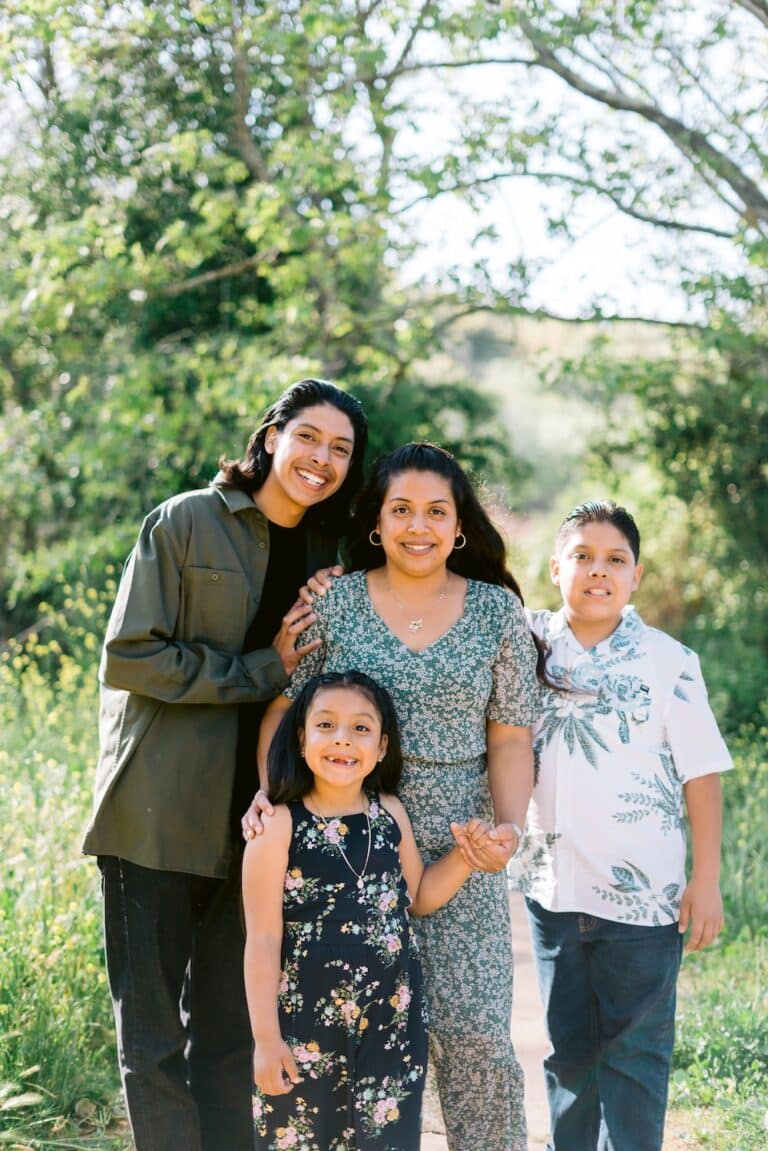 photo of smiling first grader Sebastiana with her mom and two older brothers