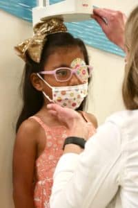 doctor preps young girl for measuring height