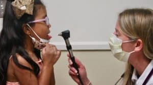 doctor examines girl's mouth