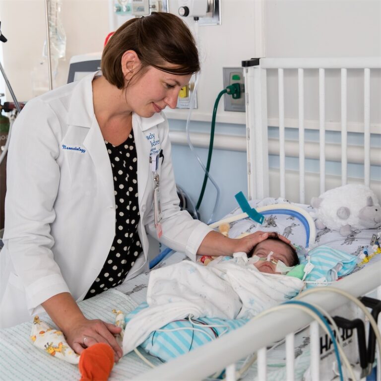 pediatrician smiles down at baby
